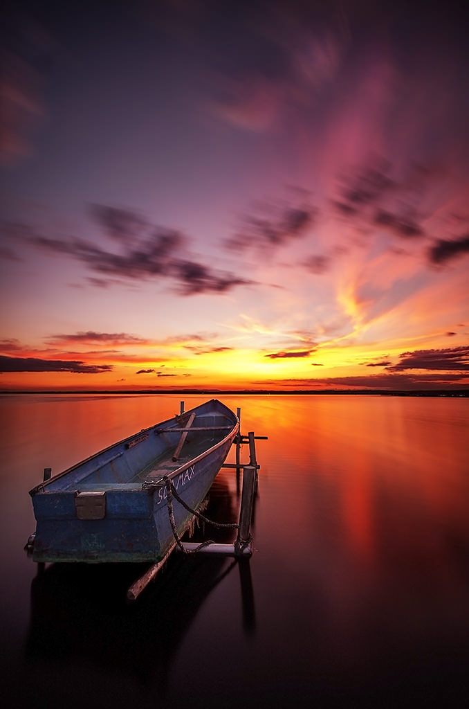Floating boat at sunset